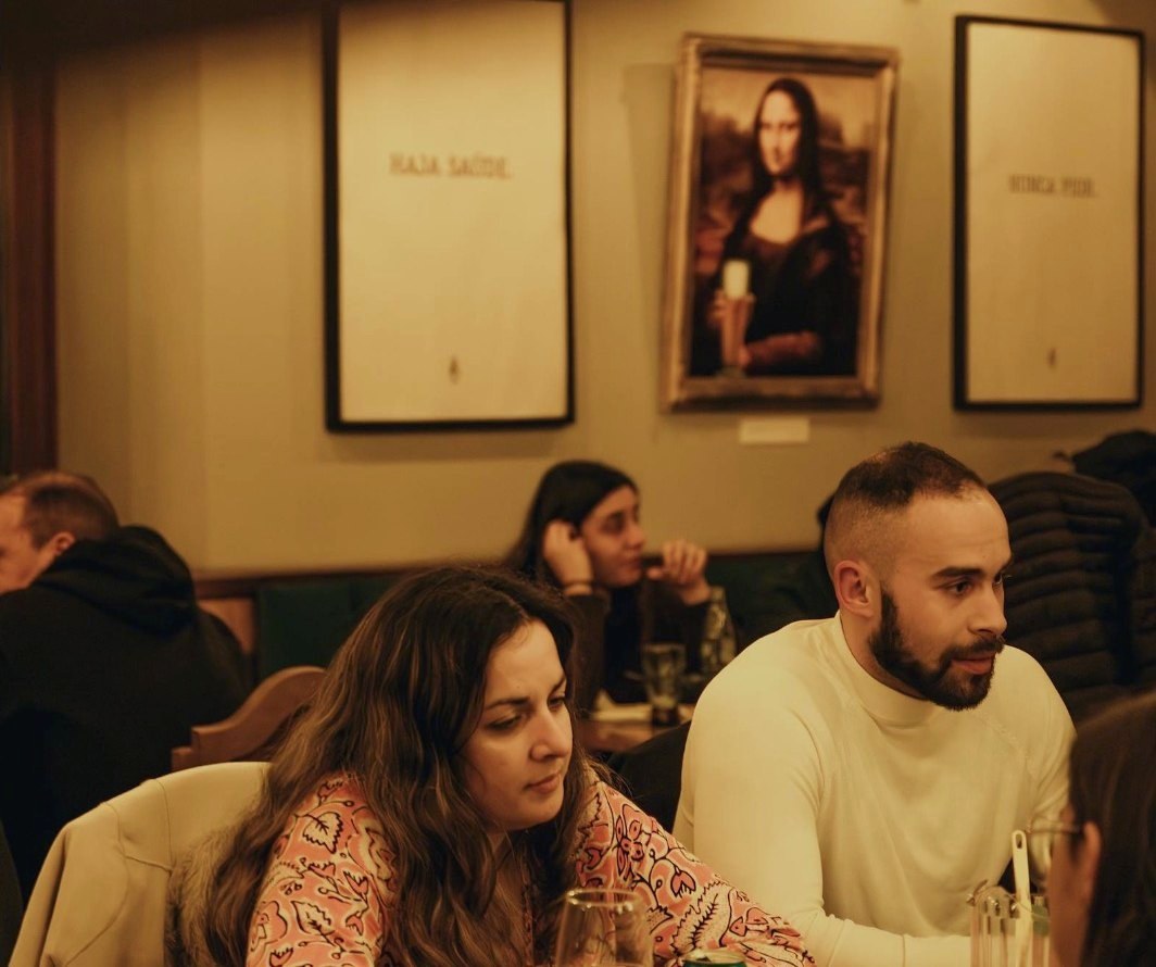 Jantar na sala, com a Mona Lisa de cerveja na mão ao fundo